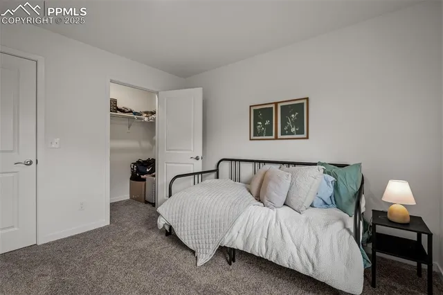 a spacious bedroom with a bed and a lamp