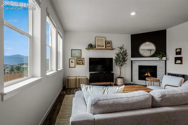 a living room with furniture a large window and a fireplace