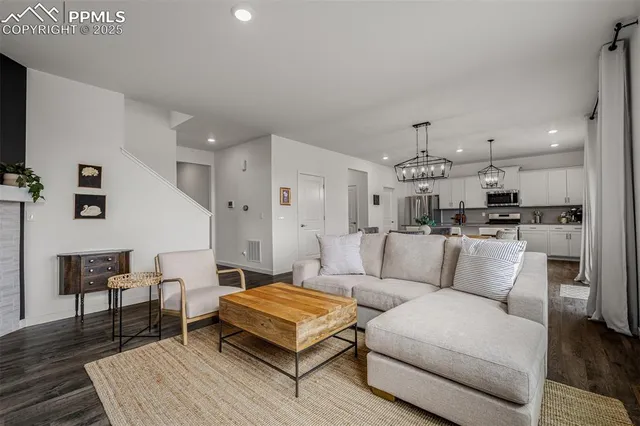 a living room with furniture and a dining table with wooden floor