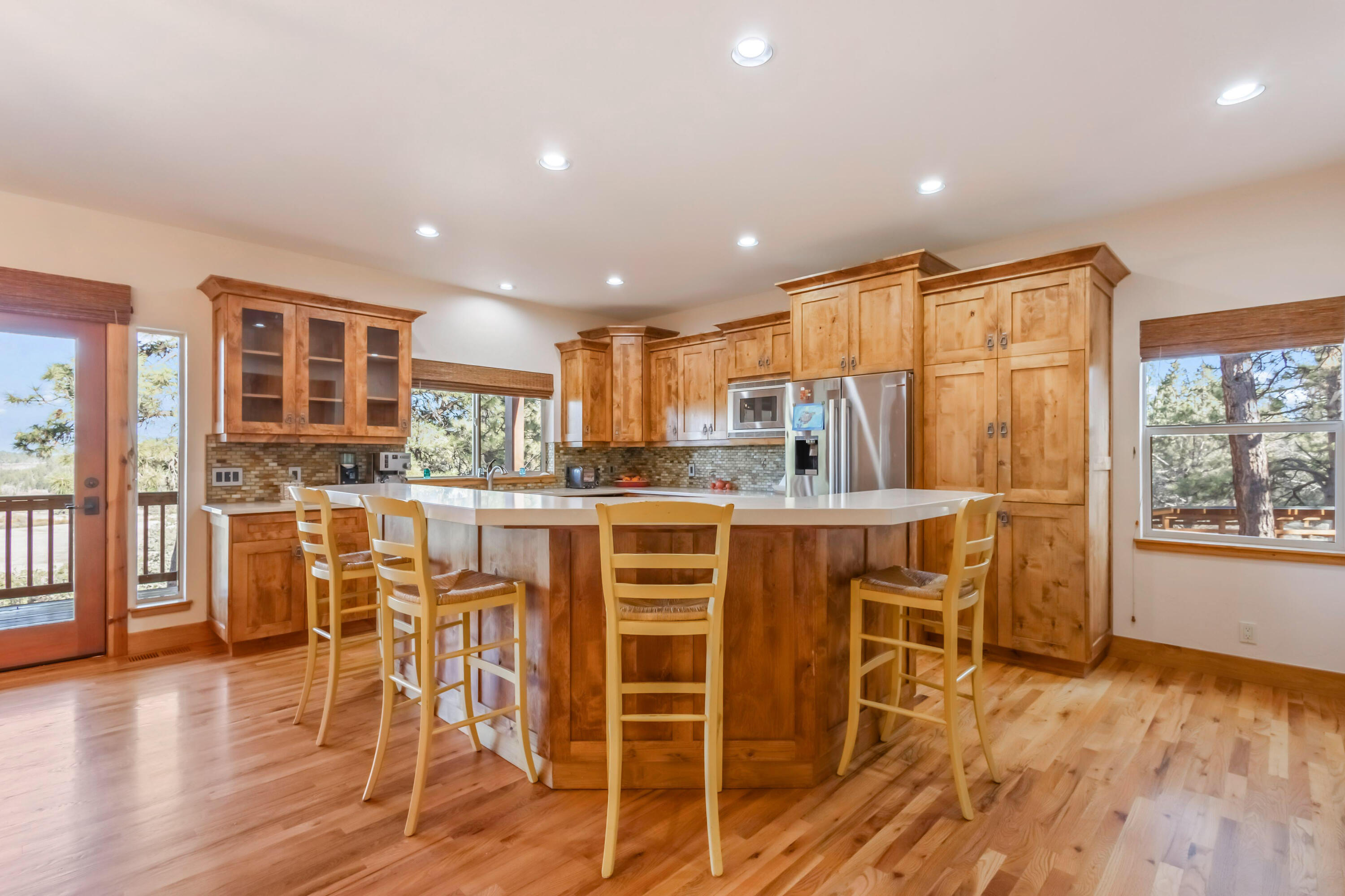 69590 Omaha Road Sisters, OR 97759 - Photo 14 of 46 a kitchen with stainless steel appliances a dining table chairs and wooden floor