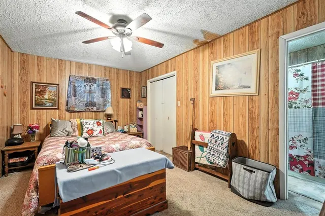 a bedroom with a bed a ceiling fan and a dresser