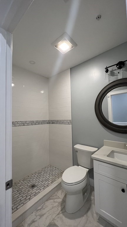 336 Cambridge Street, Unit A Burlington, MA 01803 - Photo 5 of 17 a bathroom with a toilet a sink and a mirror