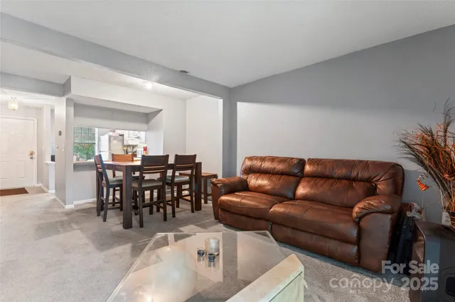 a living room with furniture a dining table with kitchen view