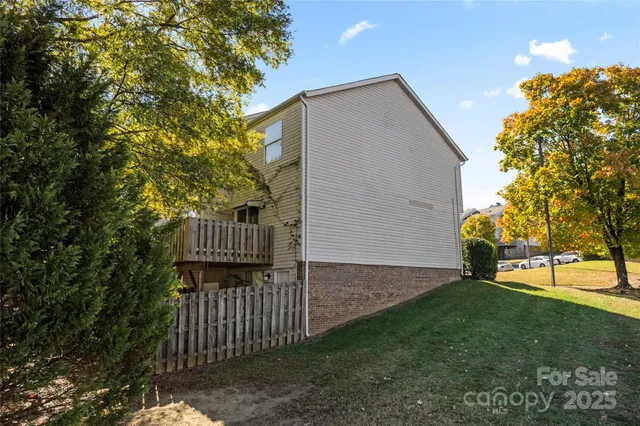 a view of a backyard with wooden fence and a bench