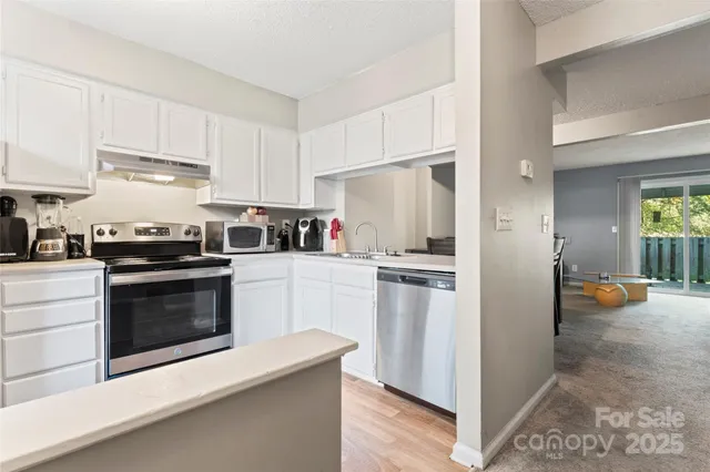 a kitchen with stainless steel appliances and white cabinets