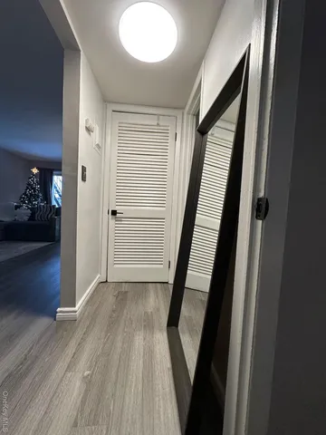 a view of a hallway view with wooden floor and staircase