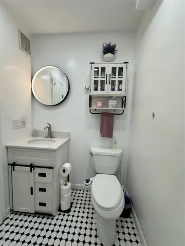 a bathroom with a sink a toilet and a mirror
