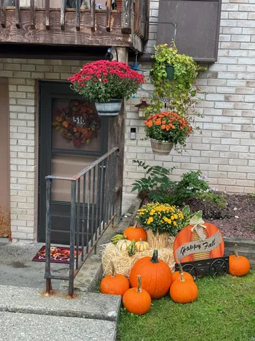a outdoor view of a house with table and chairs and potted plants