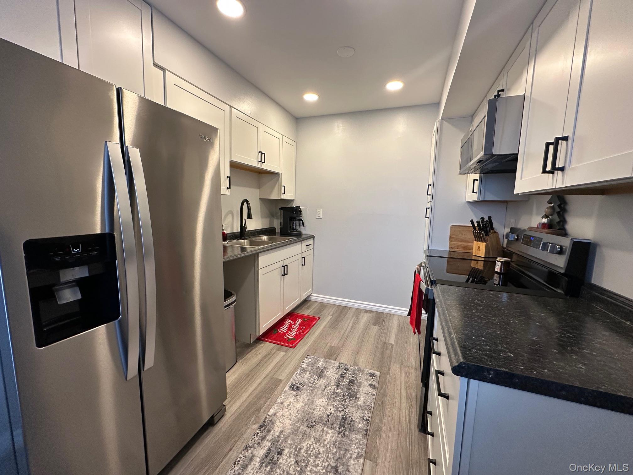 26 Cooper, Unit 510 Poughkeepsie, NY 12603 - Photo 3 of 28 Kitchen with appliances with stainless steel finishes, light wood-type flooring, white cabinets, and recessed lighting