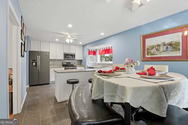 a kitchen with kitchen island a stove a table and chairs