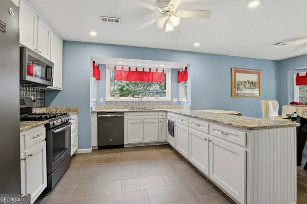 a kitchen with stainless steel appliances granite countertop a stove and a sink