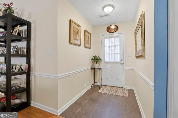 a view of a hallway to a livingroom with furniture and windows