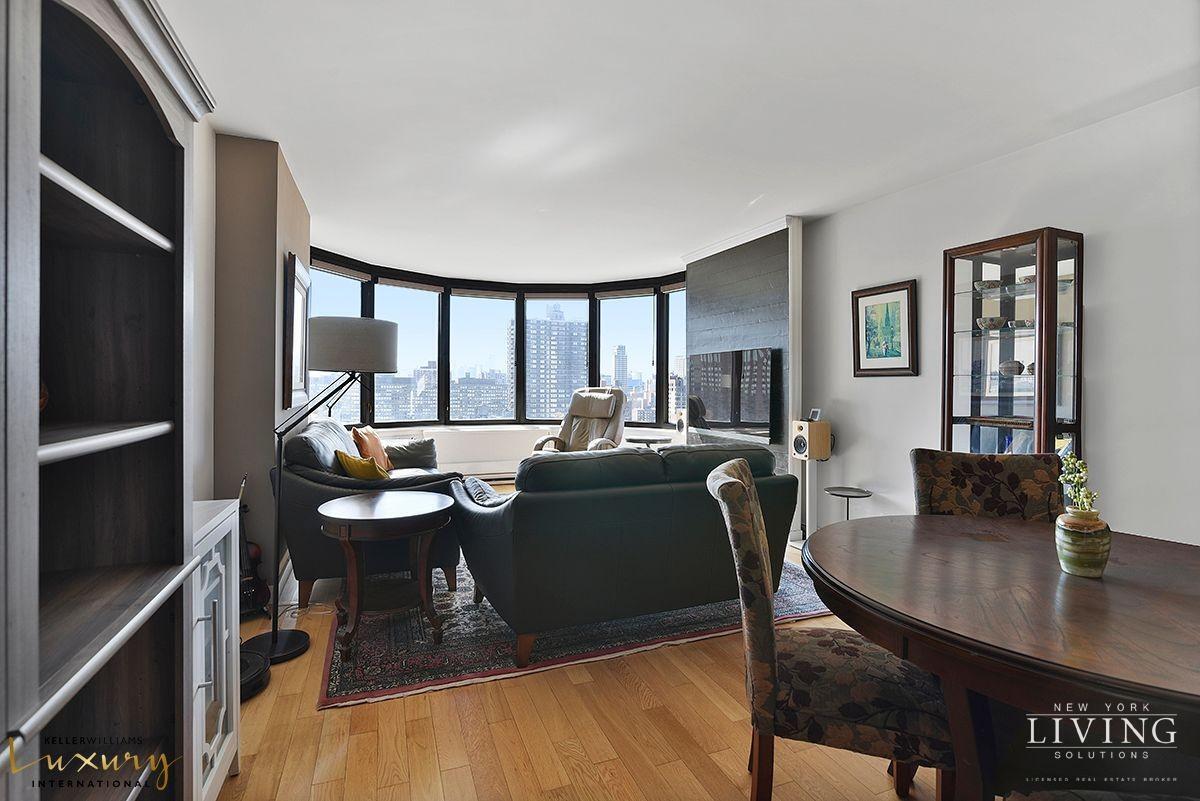 330 East 38th Street, Unit 24A Manhattan, NY 10016 - Photo 3 of 17 a living room with furniture a large window and wooden floor