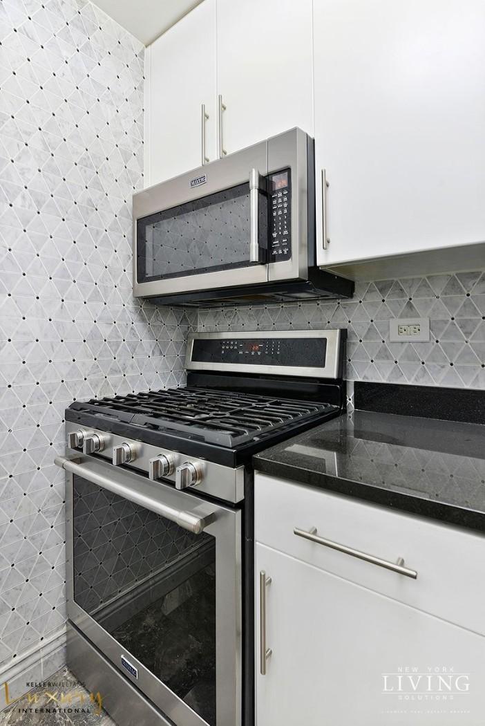330 East 38th Street, Unit 24A Manhattan, NY 10016 - Photo 5 of 17 a stove top oven sitting inside of a kitchen