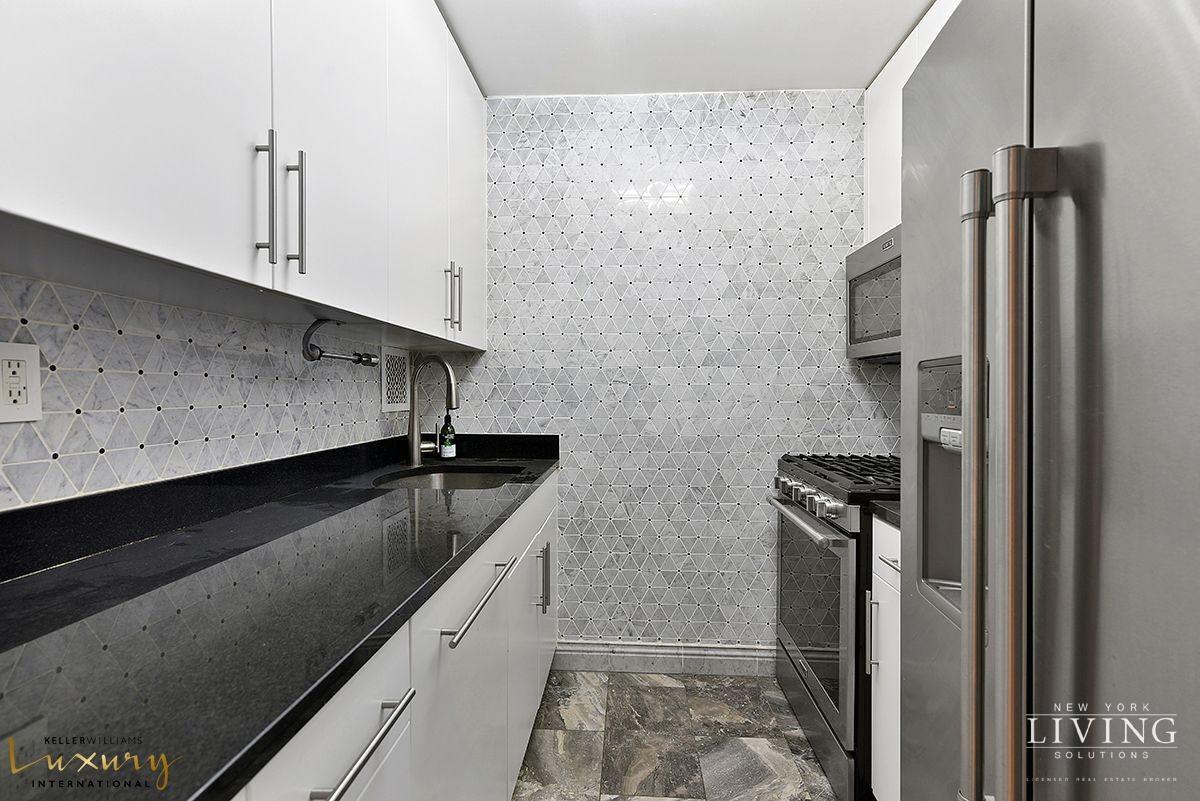 330 East 38th Street, Unit 24A Manhattan, NY 10016 - Photo 6 of 17 a kitchen with a refrigerator and a sink