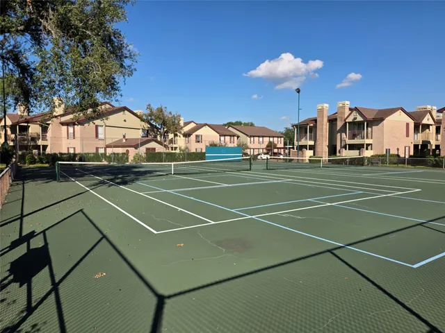 a view of a patio with table and chairs under an umbrella with a small yard