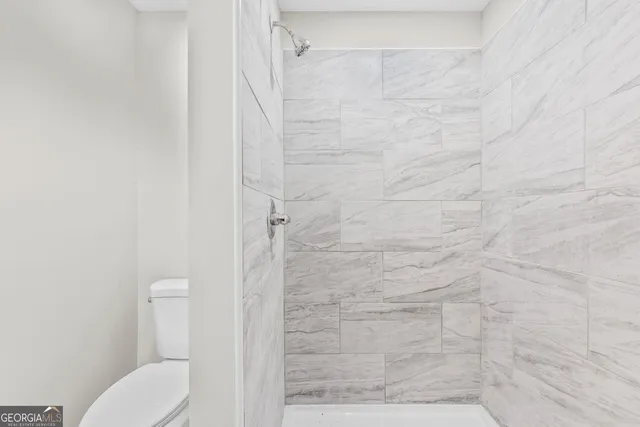 a bathroom with a toilet and a shower