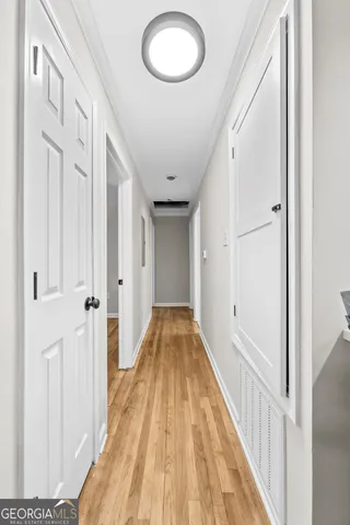 a view of a hallway with wooden floor and staircase