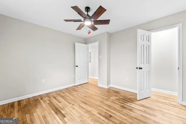 a view of a big room with wooden floor and a ceiling fan