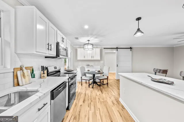 a kitchen that has a lot of cabinets in it and wooden floors
