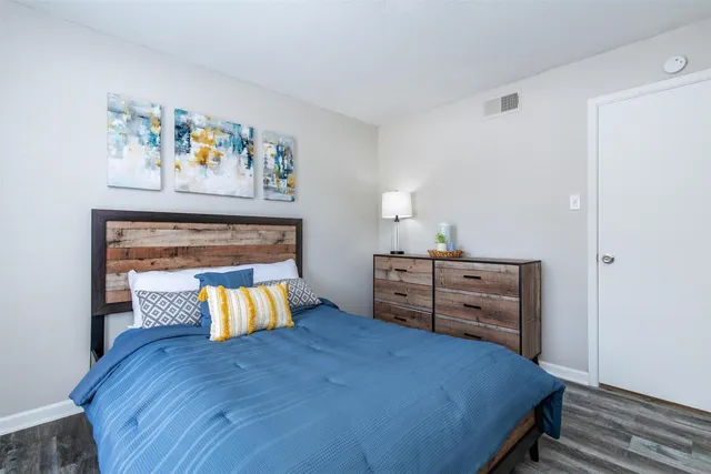 a bedroom with a bed and painting on the wall