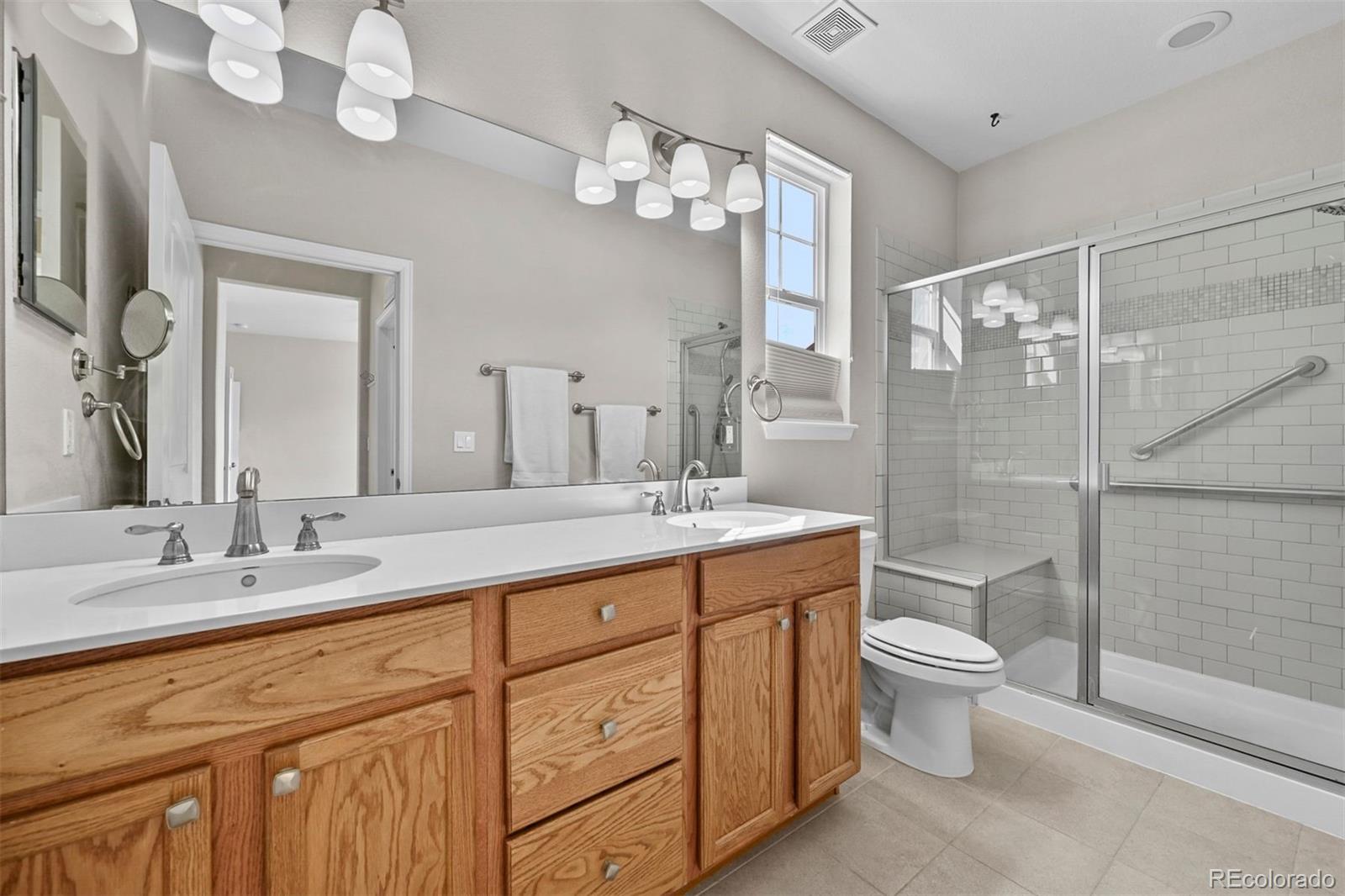1354 Promontory Bluff View Colorado Springs, CO 80921 - Photo 6 of 45 a bathroom with a granite countertop sink a toilet and a mirror