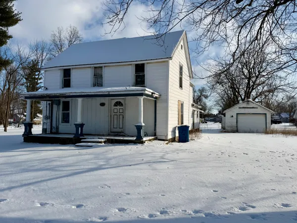 a view of a white house with a large tree