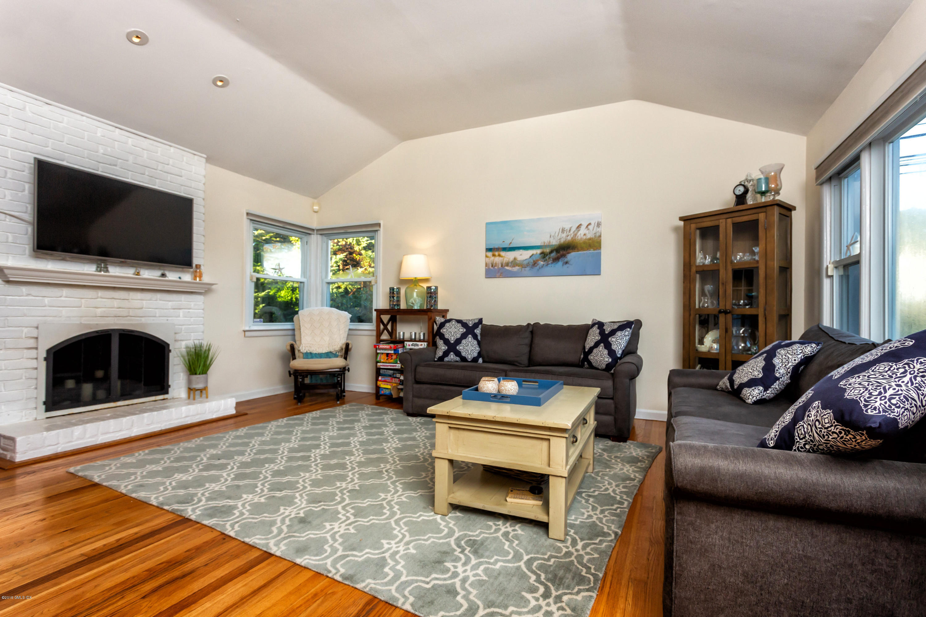 12 Mary Lane Riverside, CT 06878 - Photo 6 of 25 a living room with furniture a flat screen tv and a fireplace