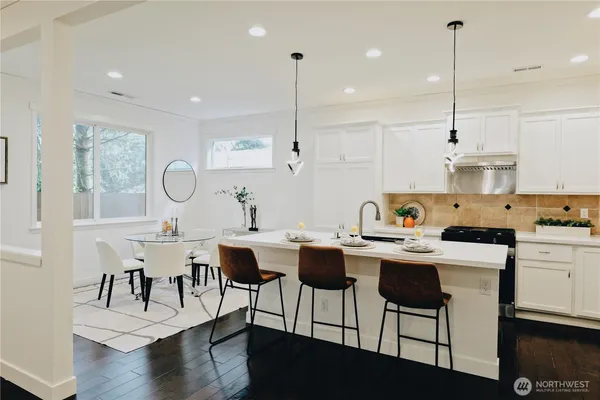 a view of kitchen with dining table chairs sink and stove