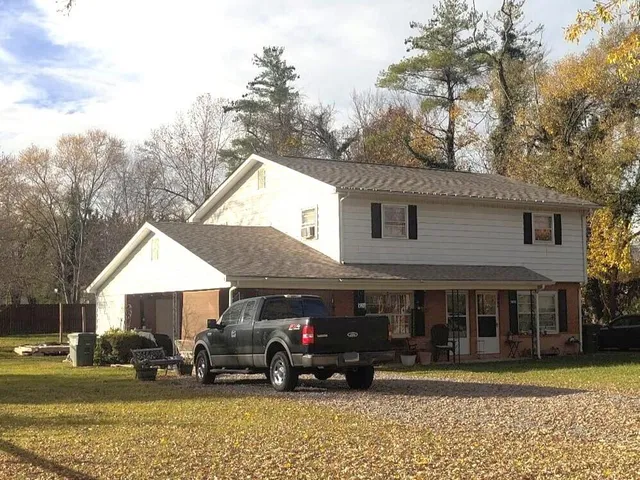 a view of a house with a patio and a yard