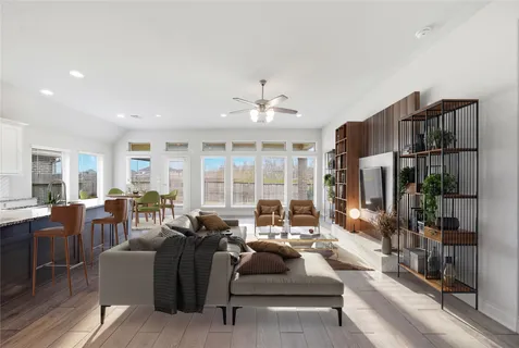 a living room with furniture fireplace and large windows