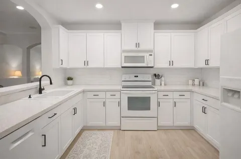 a kitchen with cabinets appliances a sink and a counter top