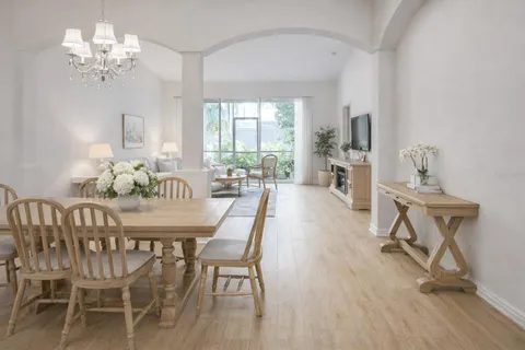 a dining room with furniture a chandelier and wooden floor