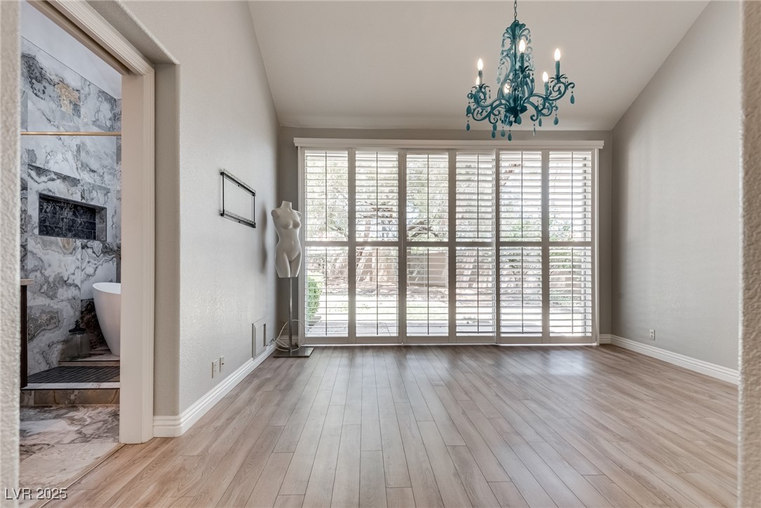 8541 Heather Downs Drive Las Vegas, NV 89113 - Photo 2 of 39 Spare room featuring a chandelier, wood finished f