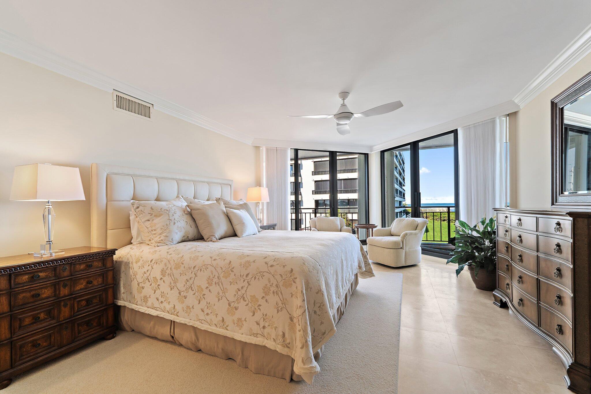 19850 South Beach Road, Unit 3D Jupiter, FL 33469 - Photo 29 of 54 a spacious bedroom with a bed and large windows