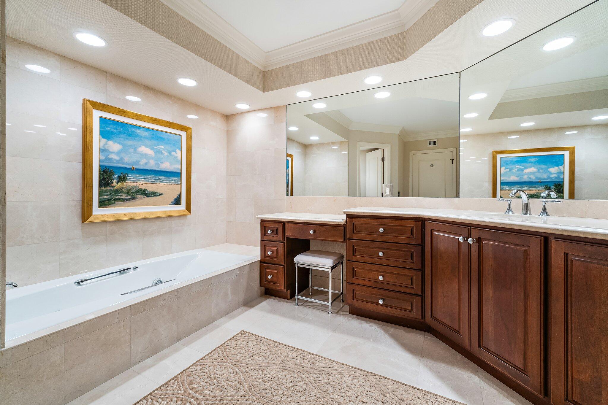 19850 South Beach Road, Unit 3D Jupiter, FL 33469 - Photo 34 of 54 a bathroom with a sink a large mirror and a bathtub