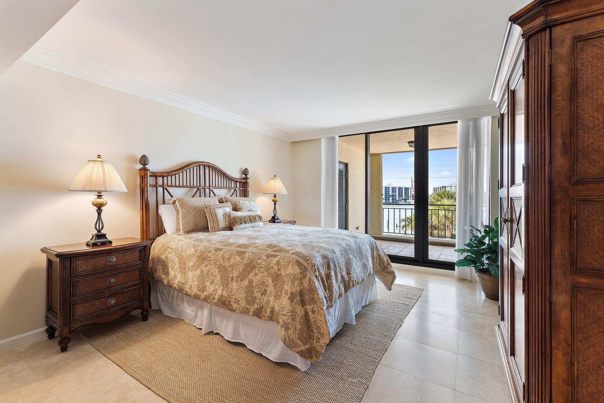 19850 South Beach Road, Unit 3D Jupiter, FL 33469 - Photo 39 of 54 a spacious bedroom with a bed lamp and large windows