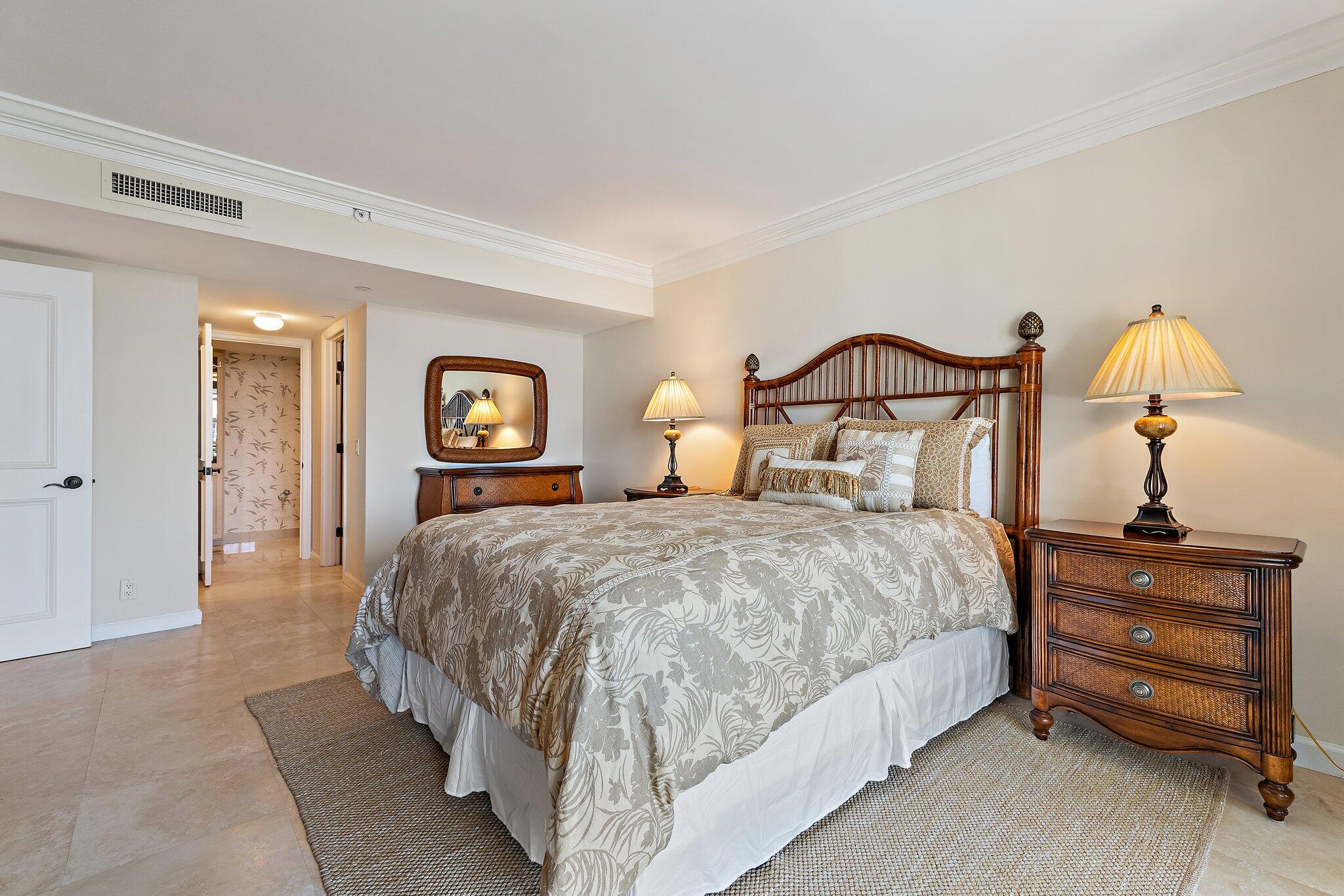 19850 South Beach Road, Unit 3D Jupiter, FL 33469 - Photo 41 of 54 a bedroom with a bed and a lamp on table