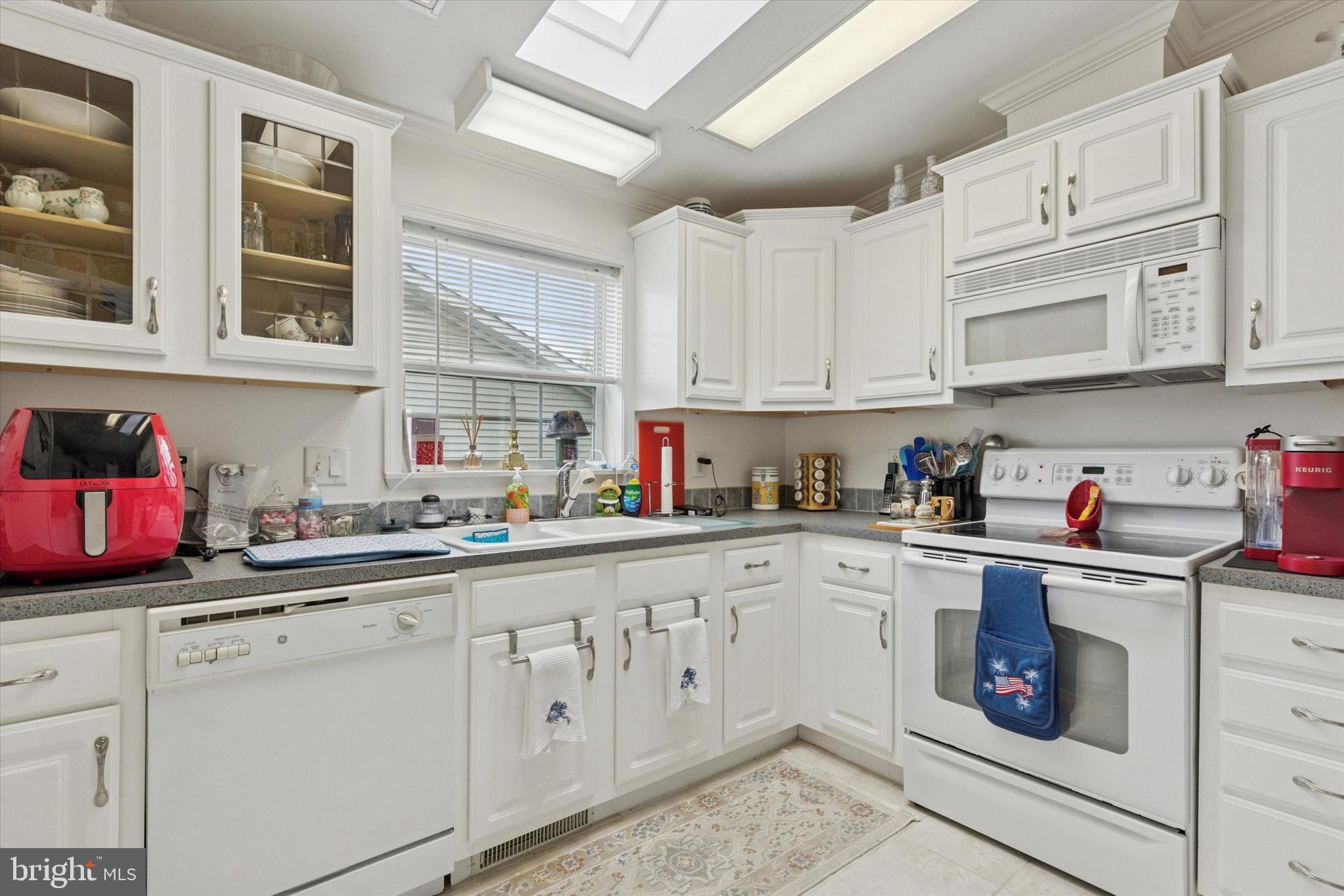 81 Random Road Douglassville, PA 19518 - Photo 9 of 31 a kitchen with stainless steel appliances granite countertop a sink dishwasher stove and cabinets with wooden floor