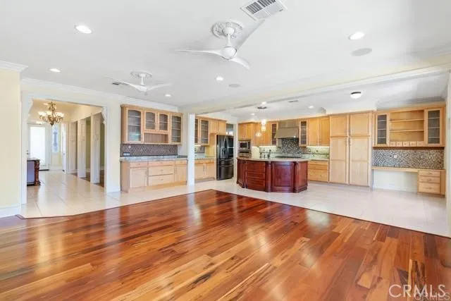 a room with stainless steel appliances wooden floor and large windows