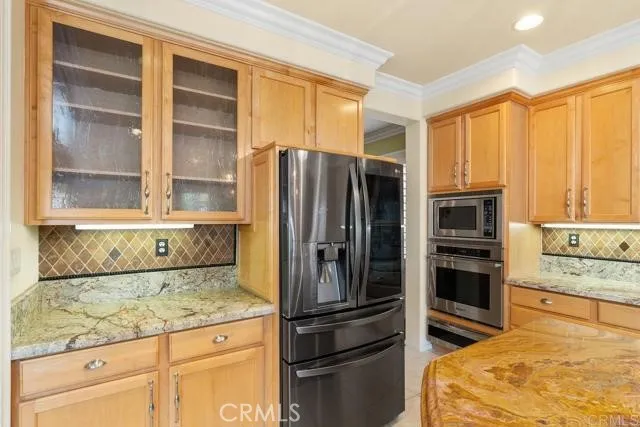 a kitchen with granite countertop a refrigerator and cabinets