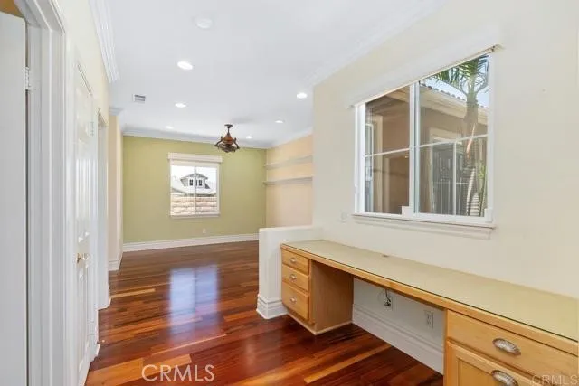 a hallway with wooden floor and windows