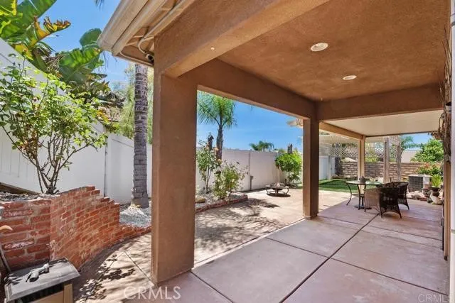 a view of a patio with couches chairs potted plants and floor to ceiling window