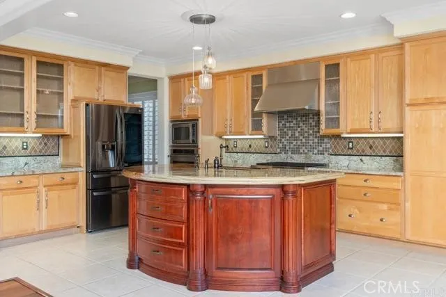 a kitchen with stainless steel appliances granite countertop a refrigerator and wooden cabinets