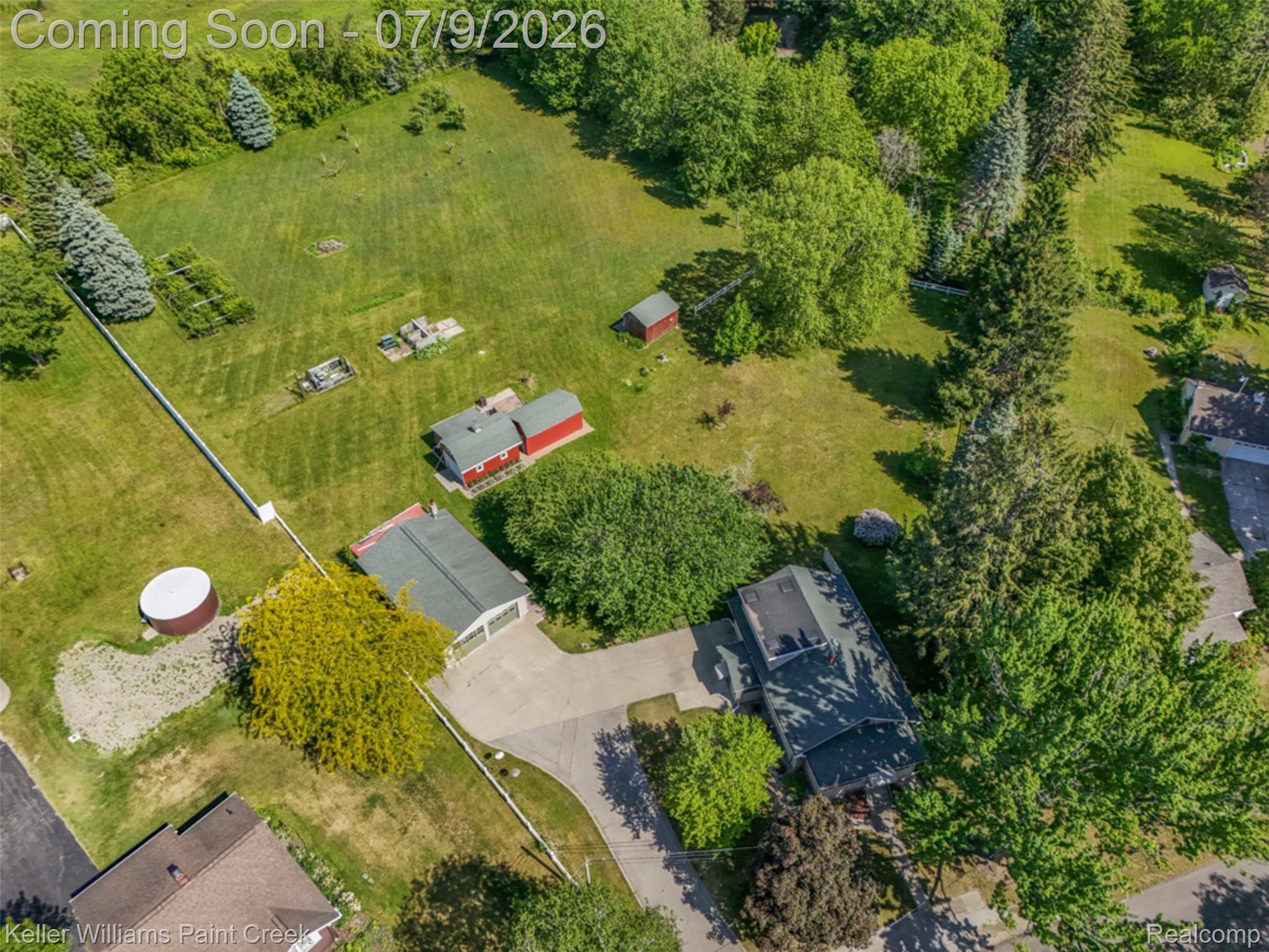 204 Russell Road Kawkawlin, MI 48631 - Photo 57 of 82 Expansive property featuring a main residence with a dark roof, a detached two-car garage, multiple outbuildings, and extensive green space with mature trees