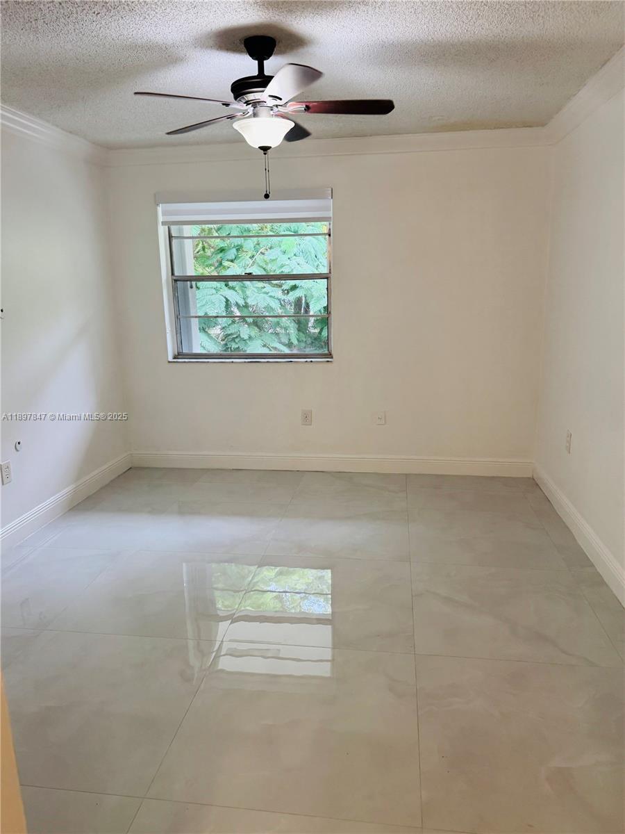 6961 Southwest 129th Avenue, Unit 7 Miami, FL 33183 - Photo 20 of 42 an empty room with windows and chandelier fan