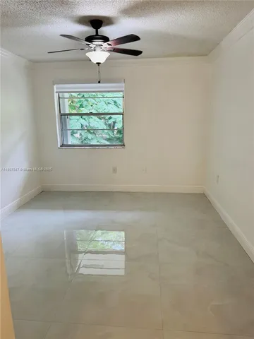 an empty room with a window and a ceiling fan