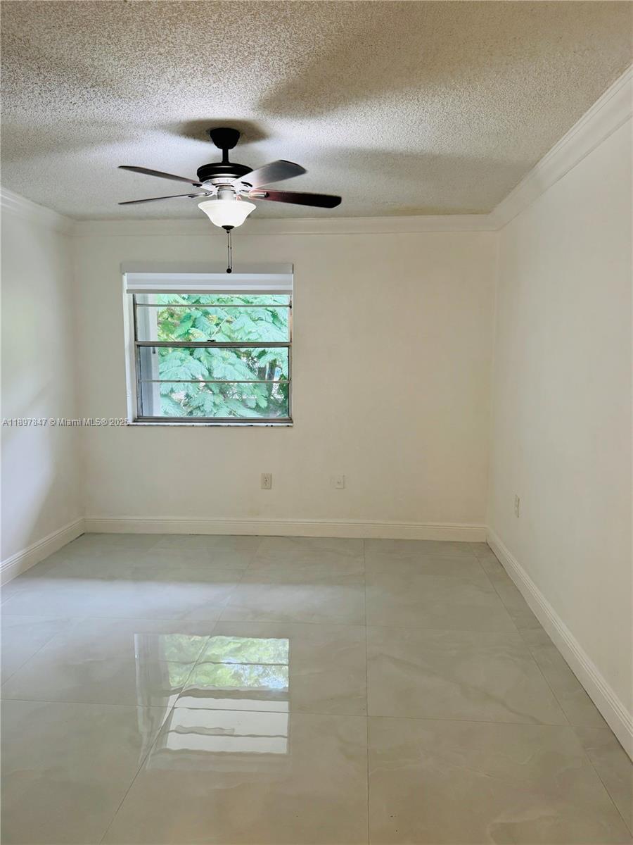 6961 Southwest 129th Avenue, Unit 7 Miami, FL 33183 - Photo 32 of 42 en empty room with windows and ceiling fan