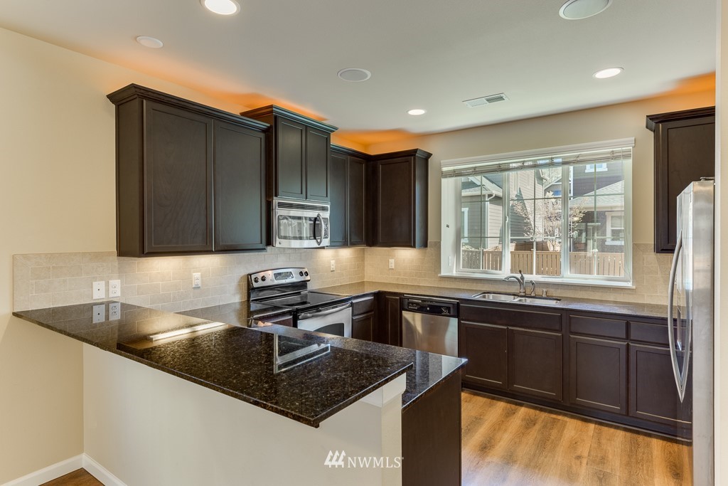 21025 40th Avenue Southeast Bothell, WA 98021 - Photo 14 of 35 a kitchen with a sink and a stove top oven with wooden floor