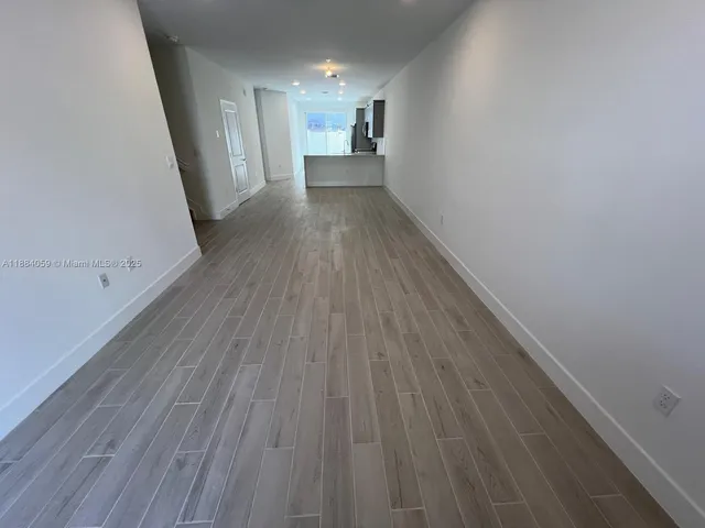 a view of kitchen with cabinets wooden floor and window